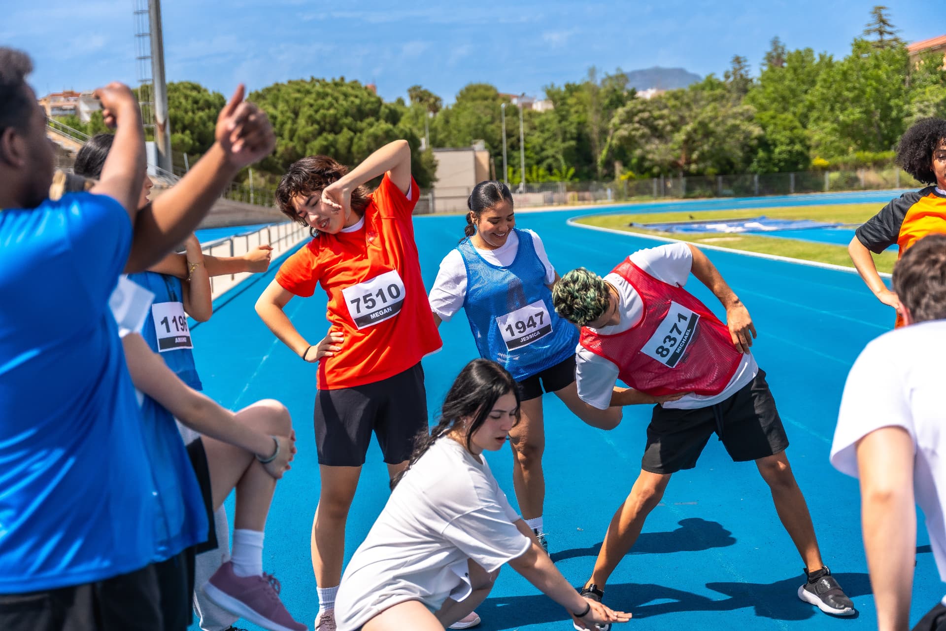 Young athletes stretching together on a running track
