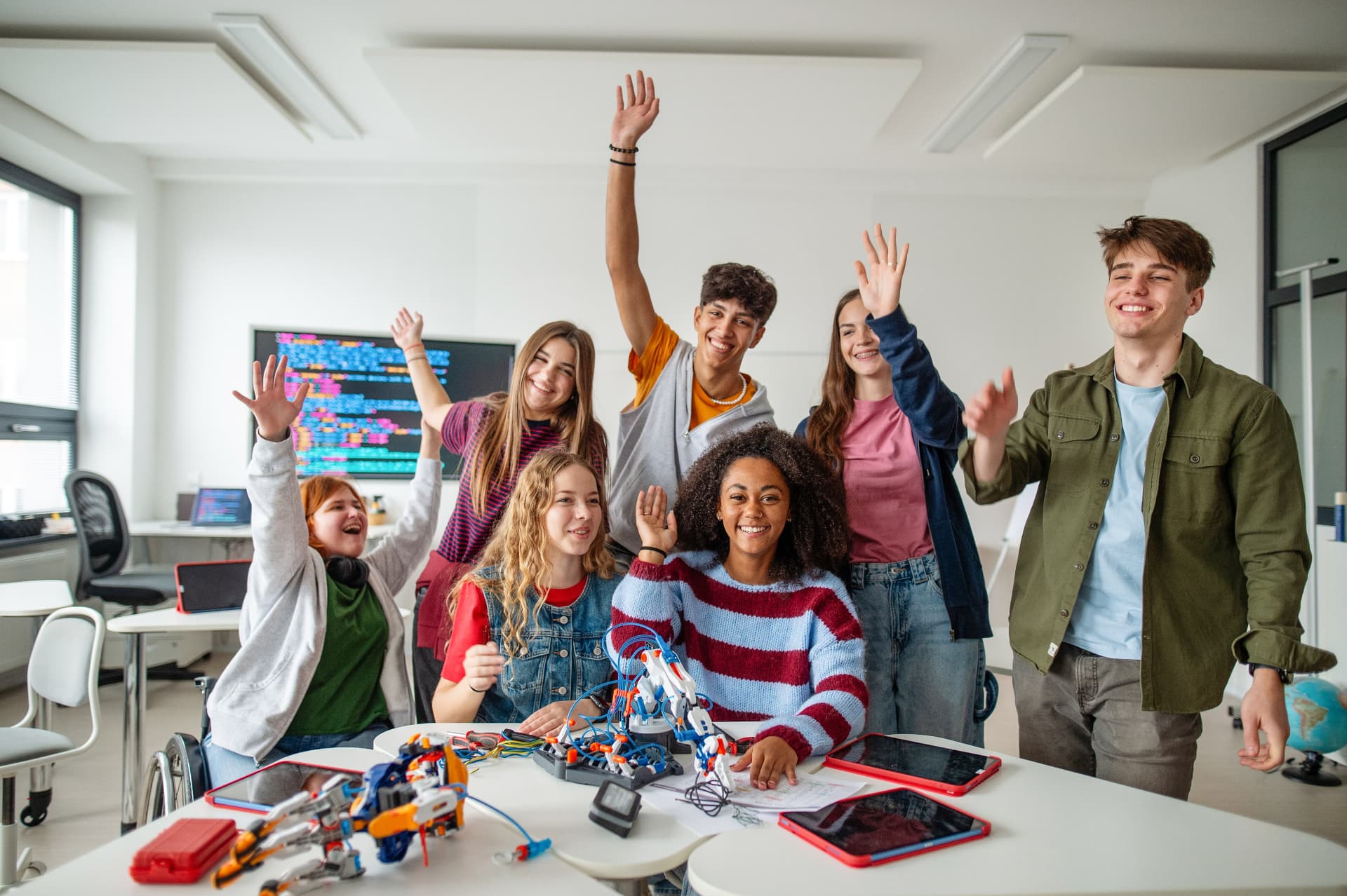 Young people learning with robotics and technology in a bright classroom