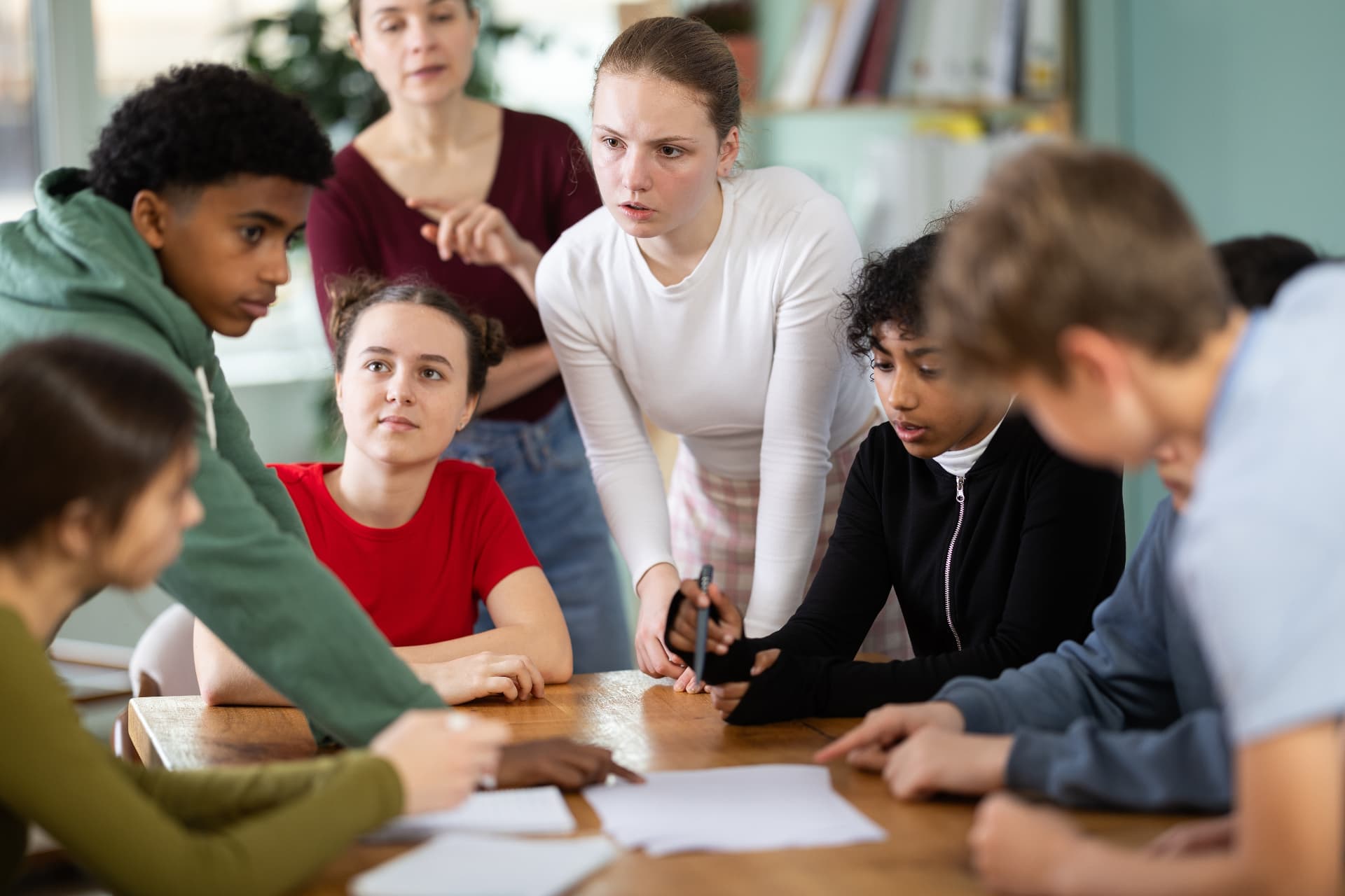 Young people learning together around a table with a mentor